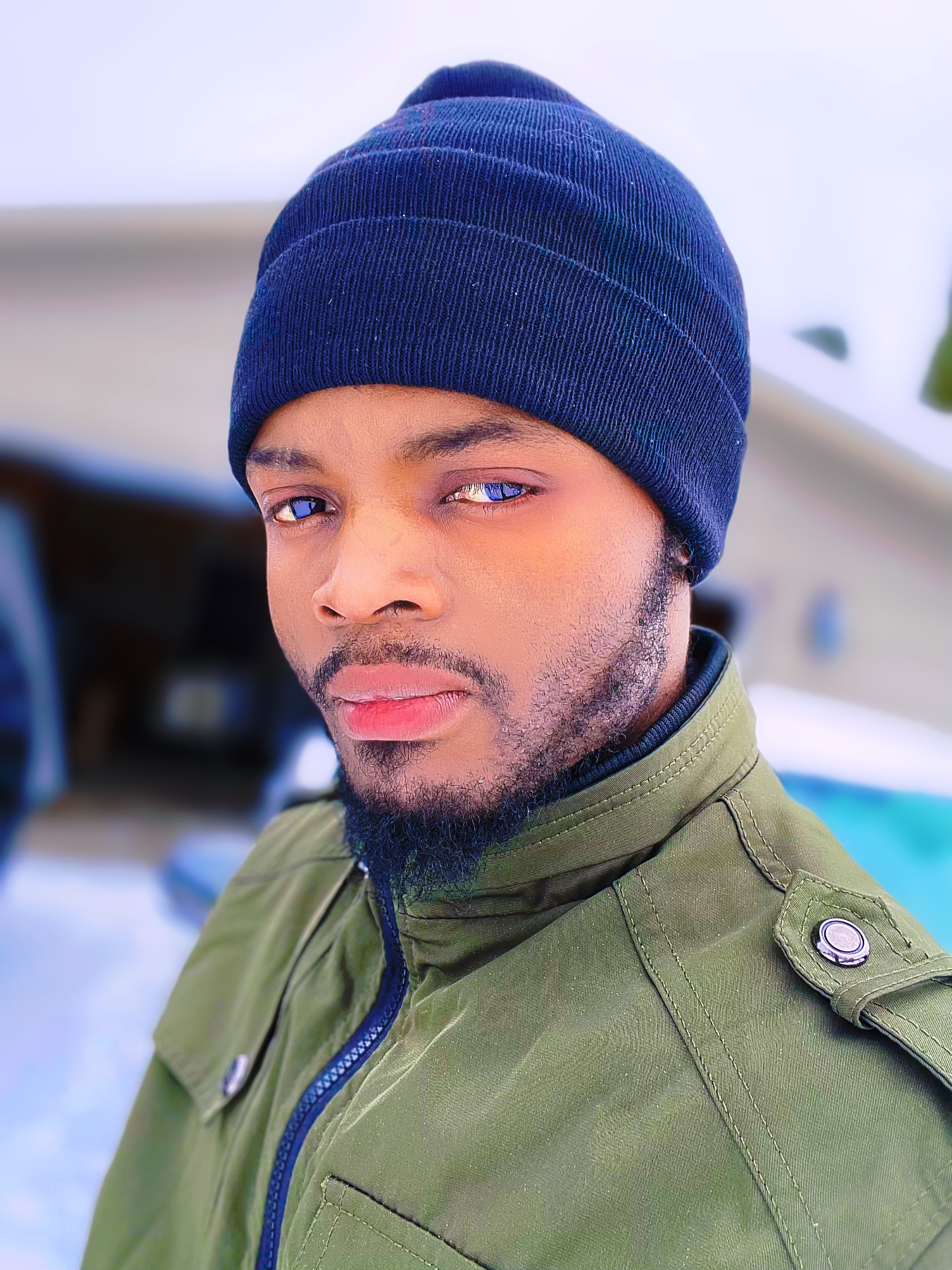 DE LA ROSE wearing a blue beanie and green jacket